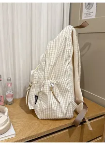 Side view of cream plaid school backpack with drawstring pocket and padded straps