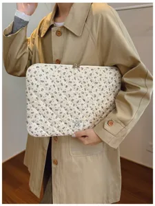 Stylish floral quilted laptop sleeve carrier shown by a model wearing a trench coat.