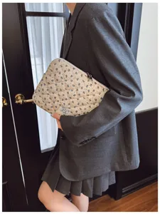 Floral quilted laptop sleeve bag carried by a model in a professional business casual outfit