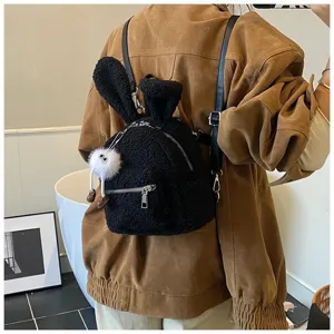 Vista trasera de una linda mochila de felpa negra con orejas de conejo y un colgante