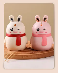Detailed shot of two cute bunny-shaped automatic toothpick dispensers on a wooden board
