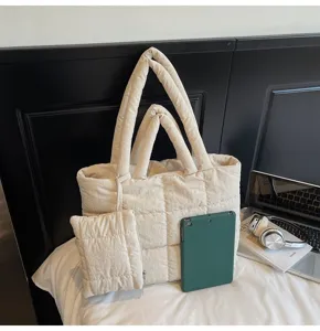 Detailopname van gewatteerde gebroken witte tote bag met bijpassend etui en accessoires