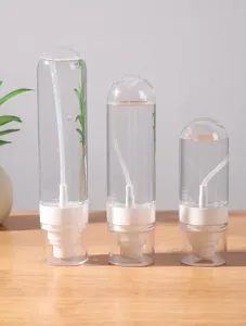 Vista dettagliata di tre flaconi spray da viaggio trasparenti di diverse dimensioni per cosmetici