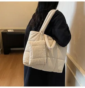 Achteraanzicht van een crème gewatteerde puffer draagtas gedragen door een vrouw.