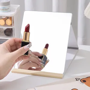 Minimalist portable folding desktop makeup mirror with gold trim on vanity table