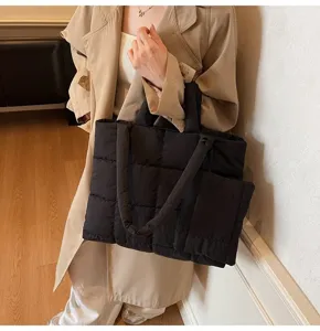 Gedetailleerd zicht op een minimalistische zwarte gewatteerde puffer tas met pouch