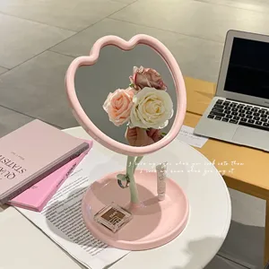 Ästhetischer tulpenförmiger Tisch-Schminkspiegel mit einer rosa Schmuckaufbewahrung.
