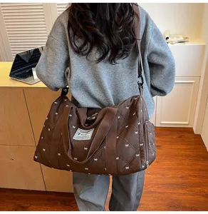 Stylish quilted travel duffel bag with bow pattern, lightweight and durable crossbody design.