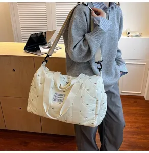 Quilted travel duffel bag with bow pattern, lightweight shoulder strap for daily gym use.