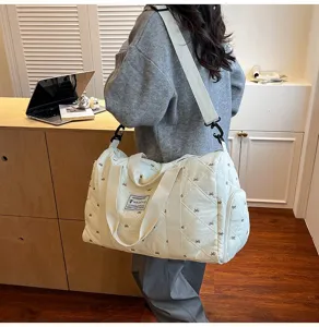 Quilted travel duffel bag with bow embroidery, casual shoulder bag for sports and fitness.