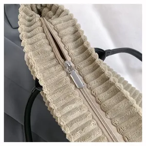 Macro-detail van de gladde metalen rits en zachte corduroy textuur van deze beige tas