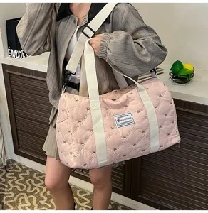 Pink quilted travel duffel bag with durable straps and stylish design for daily or sports use.