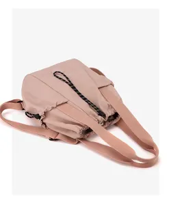 Detailed view of dusty pink nylon drawstring bag showing texture and adjustable straps