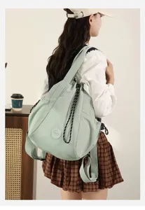 Model wearing mint green lightweight nylon shoulder bag for casual lifestyle look