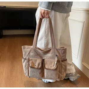 Casual tan corduroy tote bag with multiple exterior pockets held by a model indoors