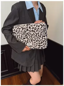 Stylish leopard print laptop sleeve shown in a lifestyle setting by a model.