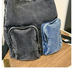 Close-up of stylish denim backpack with contrast zip pockets on a wooden desk