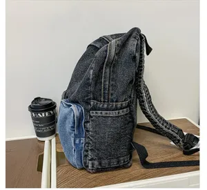 Side view of high-quality dark gray denim backpack with light blue contrast pocket