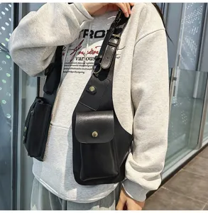 Detail of a black techwear vest chest bag with multiple functional utility pockets.