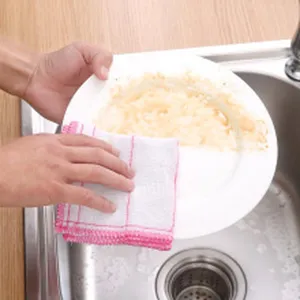 Close-up of a microfiber kitchen dishcloth cleaning greasy residue off a white plate