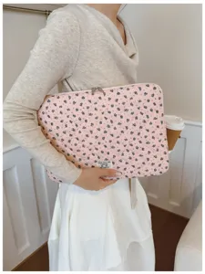 Stylish floral quilted laptop sleeve for 11-15 inch notebooks held in daily setting