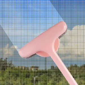 Close-up detail of a pink static cleaning brush removing dust from a window mesh screen