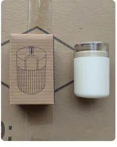 Detailed view of the portable push-type toothpick holder with its cardboard packaging.
