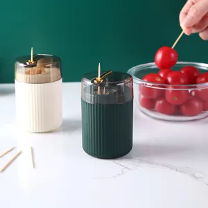 Elegant dark green and white press-type toothpick holders on a white marble surface