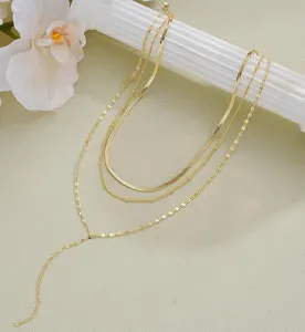 Gros plan d'un collier doré multi-rangs en forme de Y avec détails de chaînes