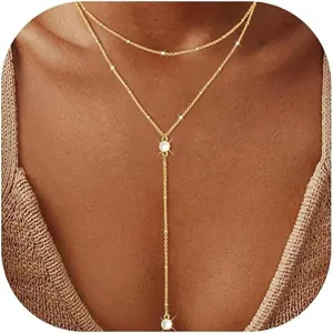 Vue détaillée d'un collier doré double épaisseur avec pendentif gland et pierres CZ