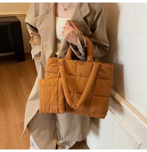 Detailopname van een stijlvolle mosterdbruine gewatteerde shopper bij een trenchcoat