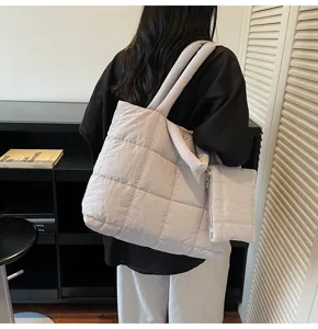 Model met een beige gewatteerde katoenen shopper, achteraanzicht in een minimalistische kamer.