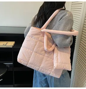 Gedetailleerd overzicht van een roze gewatteerde puffer-tote bag met bijpassend tasje.