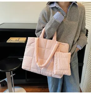 Detailweergave van een roze gewatteerde katoenen shopper met bijpassend tasje op een model