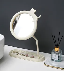 Dettaglio dello specchio da trucco color crema con silhouette di gatto e vassoio base