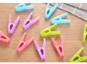 Multicolor plastic windproof clothespins scattered on a wooden surface for clothes drying