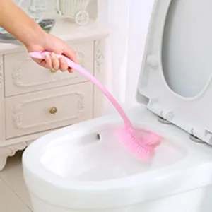 Action shot of a pink long-handle plastic toilet brush cleaning a white bowl.
