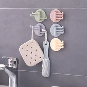 Set bunter mehrarmiger Klebehaken mit Schwamm und Bürste im Badezimmer an der Wand