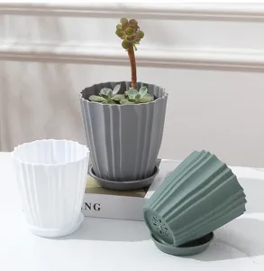 Detail van moderne plastic bloempotten met verticale groeven en drainagegaten.