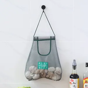 Sac de rangement suspendu en filet pour fruits et légumes de cuisine sur un mur