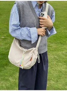 Beige Cord-Umhängetasche im japanischen Stil an einem Model in natürlicher Umgebung
