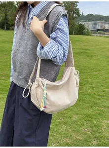 Beige Cord-Umhängetasche im japanischen Stil, von einem Modell getragen