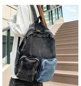 Detailed back view of a stylish distressed denim backpack worn by a model