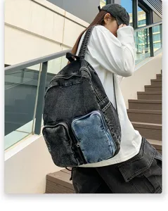 Side view of a trendy denim backpack worn by a model in a modern urban outdoor setting