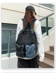 Back view of a stylish black acid wash denim backpack with contrast blue pocket