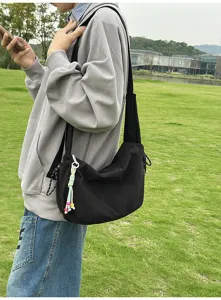 Nahaufnahme einer schwarzen Umhängetasche aus Canvas im Harajuku-Stil
