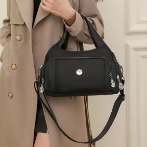 Stylish black nylon crossbody bag shown as a handheld accessory for a modern look.