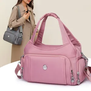 Large capacity pink nylon crossbody bag with multi-functional pockets for travel use.