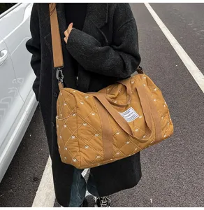 Close-up view of the brown quilted travel duffel bag with cute bow prints and durable straps.
