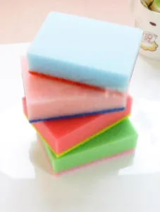 Macro view of multicolored double-sided kitchen cleaning sponges stacked on a white surface